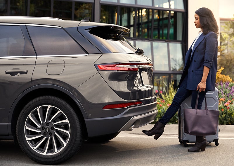 A woman with her hands full uses her foot to activate the available hands-free liftgate. | Karl Malone Lincoln in El Dorado AR