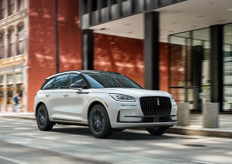 The 2024 Lincoln Corsair® SUV with the Jet Appearance Package and a Pristine White exterior is parked on a city street. | Karl Malone Lincoln in El Dorado AR